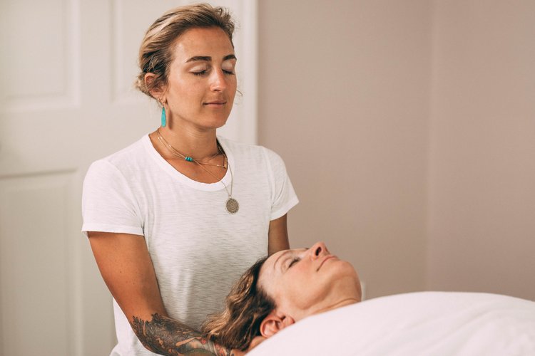 Andrea working hands-on with a client's neck on the treatment table